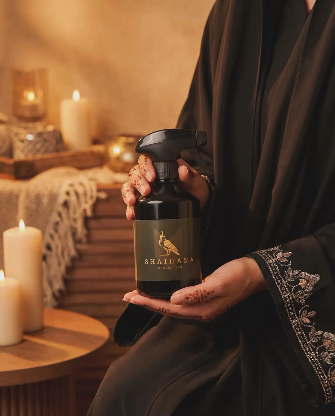 عبوة رذاذ عطري بيد ترتدي عباءة